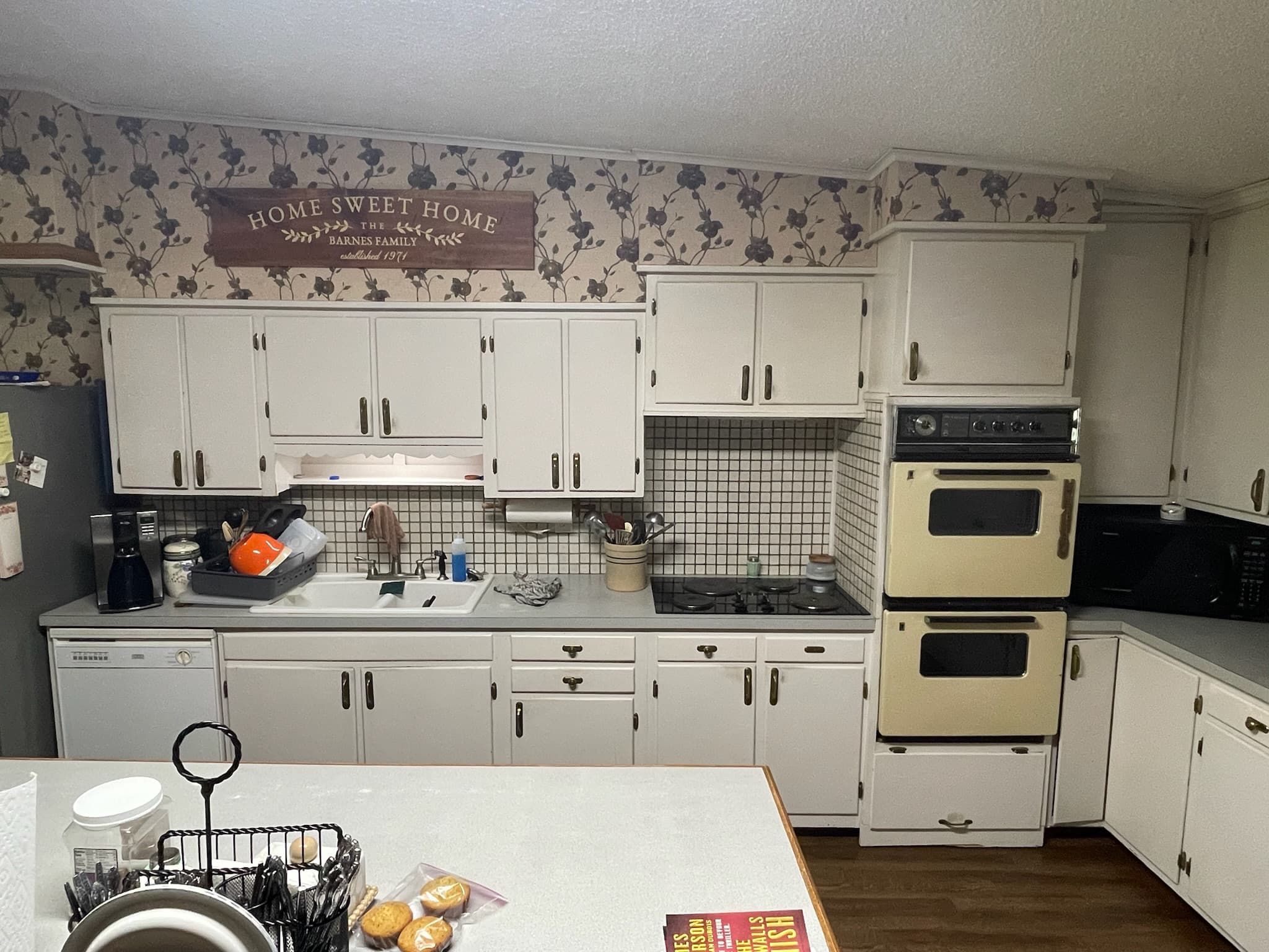 Barnes kitchen before renovation — dated cabinets and wallpaper